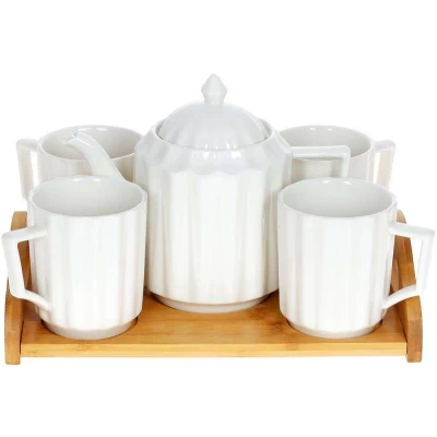 Clear textured glass teapot with amber-handled cups and brewed tea